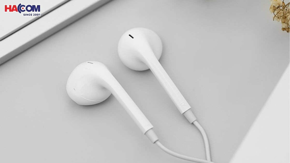 Một người phụ nữ đang chọn lựa tai nghe tại cửa hàng, gợi ý địa điểm mua sắm uy tín